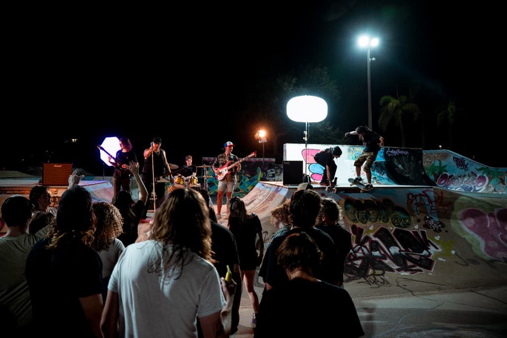 Band, skateboarders, and crowd during the Crashing Down shoot