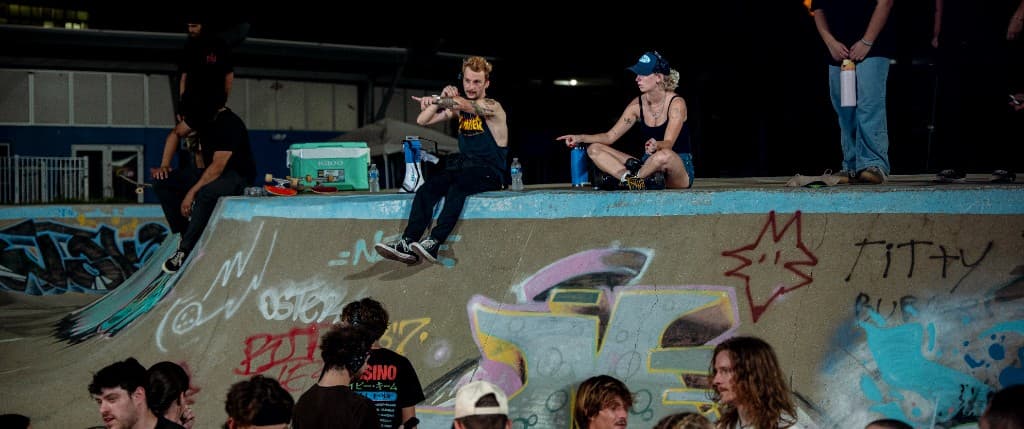 Brendan and Annaya pointing from the skate bowl ledge