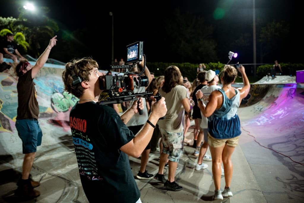 Camera operator filming the crowd from behind