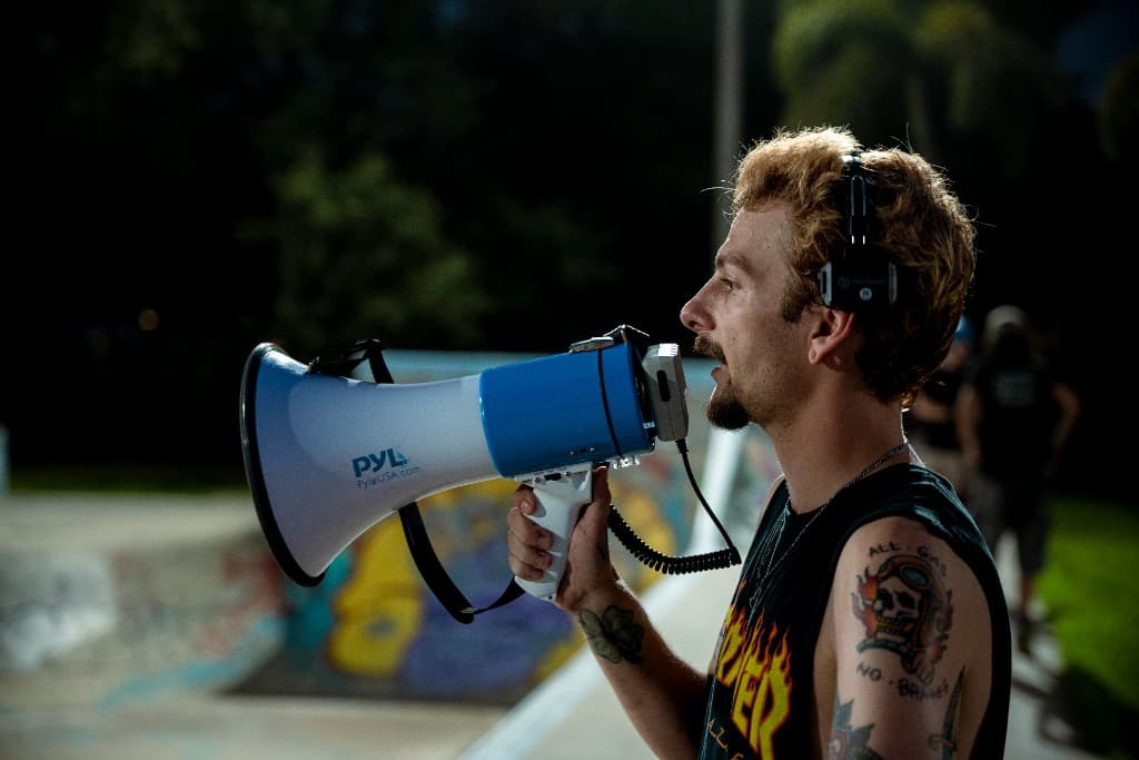 Brendan calling action with a megaphone on set