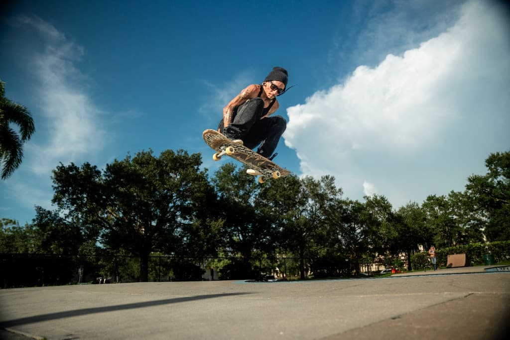 Skateboarder mid-air against a blue sky